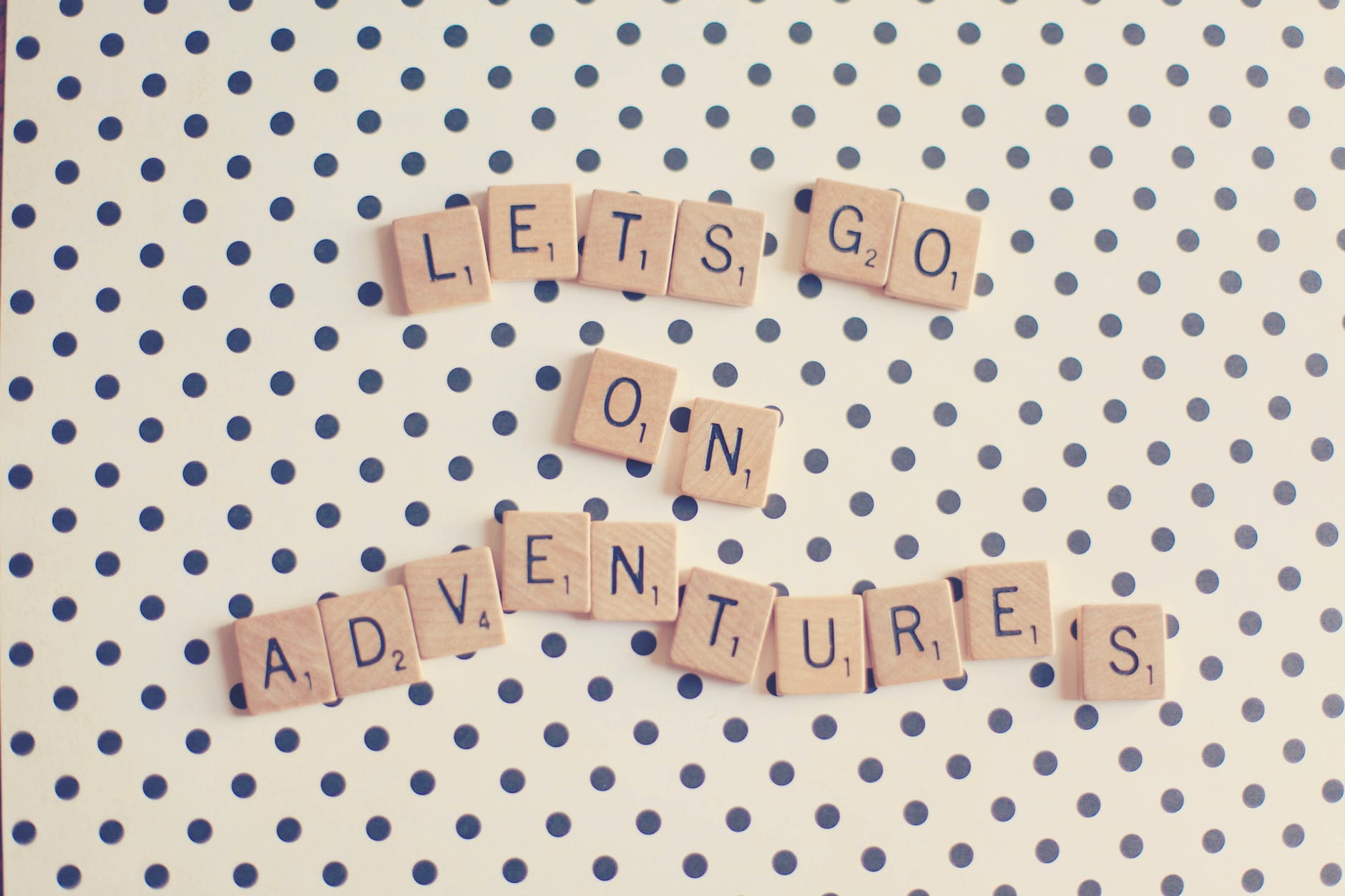 Scrabble tiles spelling out LETS GO ON ADVENTURES