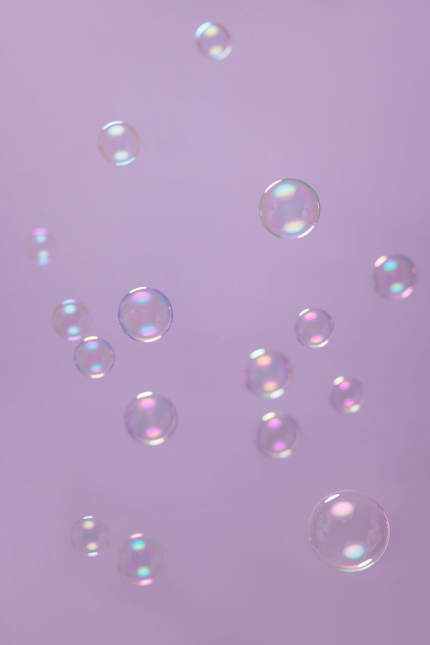 Several soap bubbles of varying sizes against a lilac background