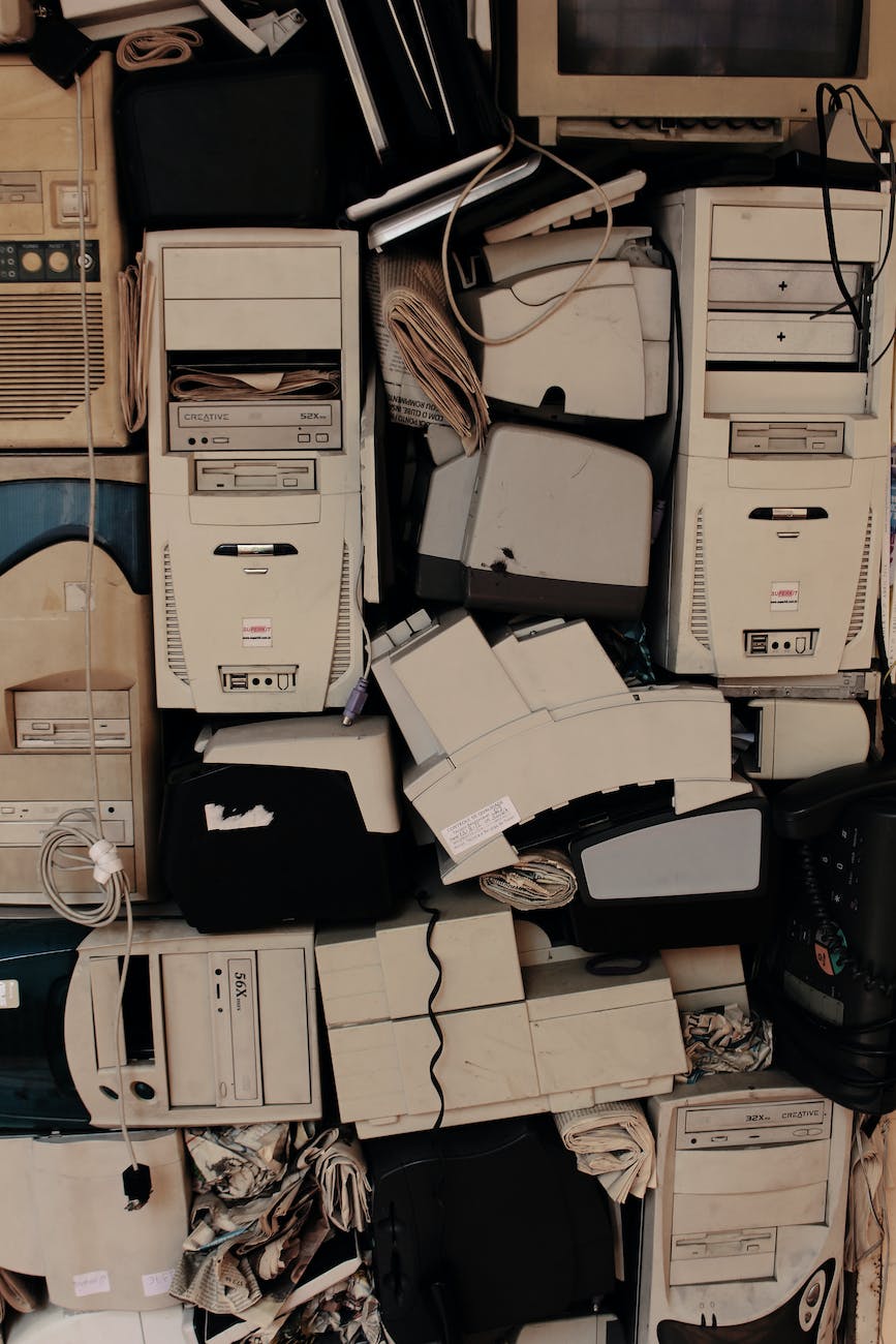 a pile of old, discarded electronic devices and computer parts, creating a sense of technological obsolescence and clutter.