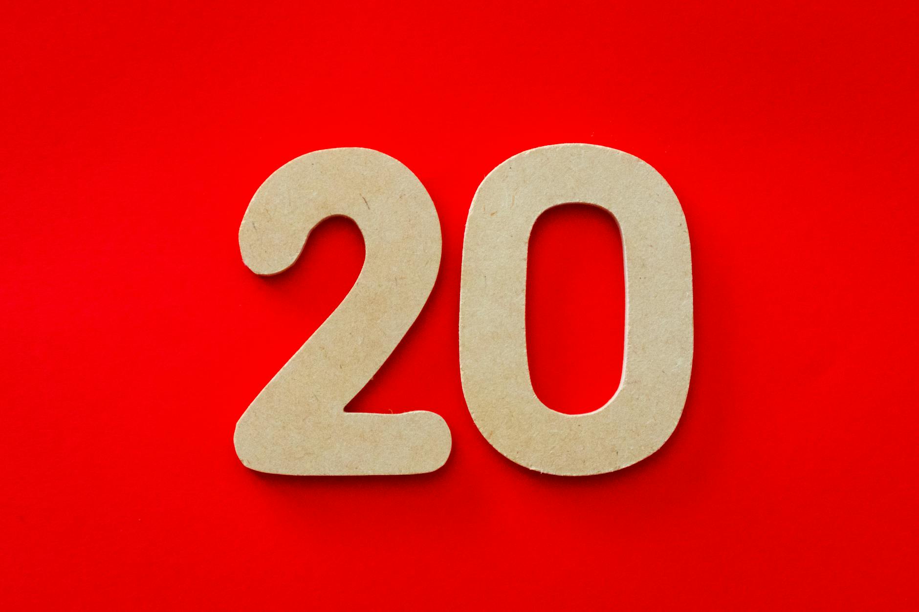 The number "20" in a cardboard cutout placed against a bright red background