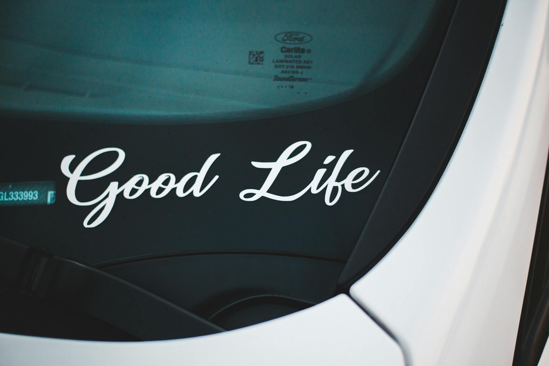 A car windshield with the phrase "Good Life" written on it.