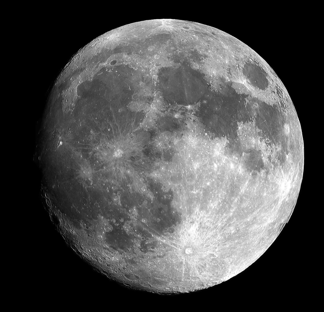A detailed black and white image of the Moon, showing its surface with various craters and lunar maria (the darker, flat regions).