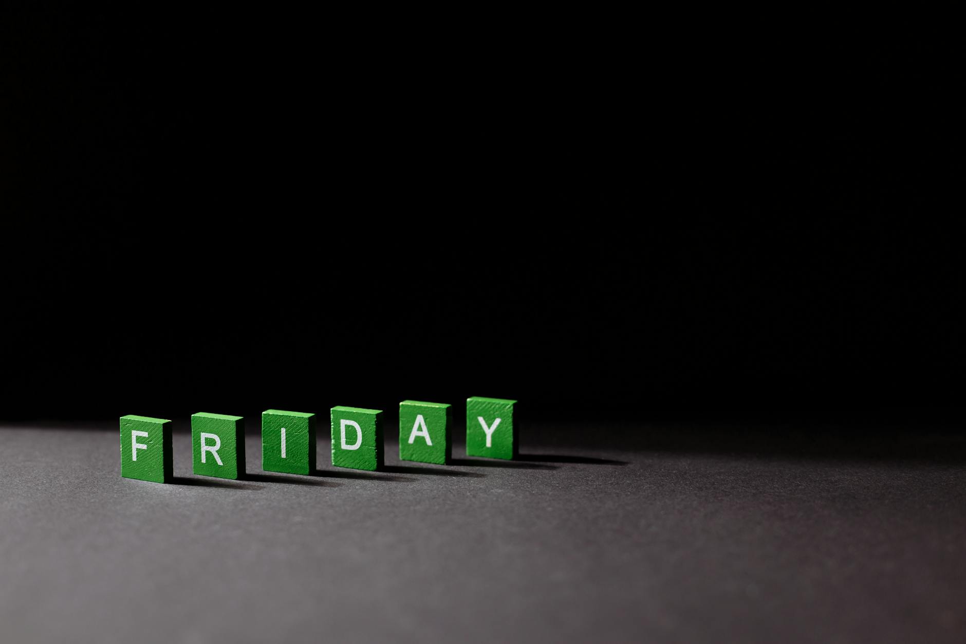 Green blocks spell out "FRIDAY" against a dark background, creating a minimalistic and modern design.