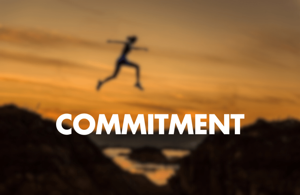 "Text 'COMMITMENT' with a blurred image of a person jumping"