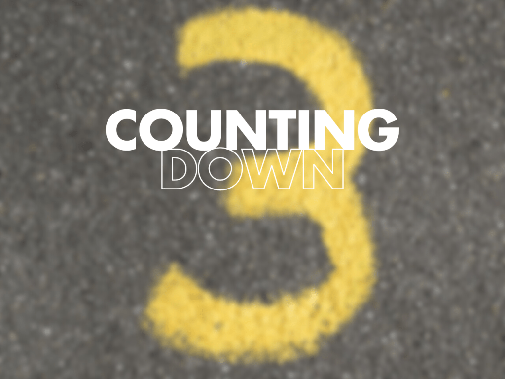 The image shows the title "Counting Down" superimposed on blurred tarmac with a yellow number 3 painted on it.