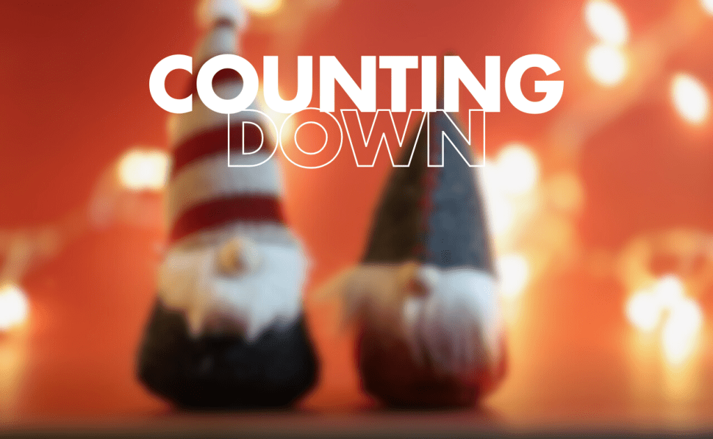 two gnomes in front of a red background with white lights. The words "COUNTING DOWN" are written above the gnomes in white text