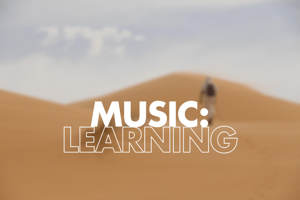 The image displays the text "MUSIC: LEARNING" against a backdrop of desert dunes out of focus. A figure in walking on the dunes.