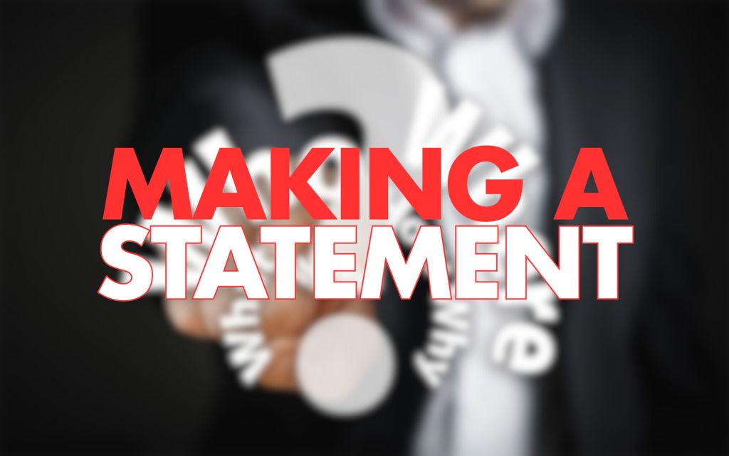 A blurred image of a person in a suit holding a question mark, with the words "MAKING A STATEMENT" prominently displayed in large, bold red text.