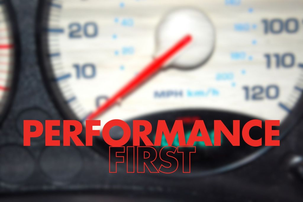 An abstract image of a speedometer in a vehicle dashboard, slightly out of focus, showing a needle pointing to a speed measurement. The foreground features the words "PERFORMANCE FIRST" in bold red text,.