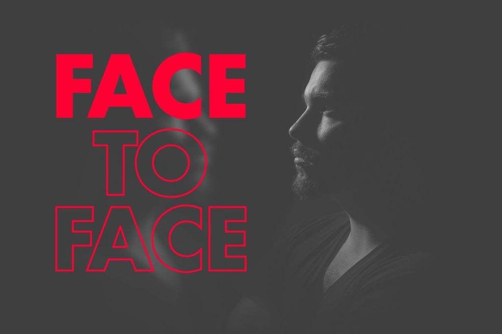 The image features a dramatic black-and-white photo of a man in profile, with strong contrasts and shadows. The bold text "FACE TO FACE" is displayed prominently in bright red, drawing attention to the theme of direct interaction or confrontation. The combination of the stark visual and vibrant typography creates a striking effect that captures the viewer's attention.


