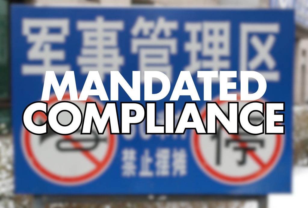 A blue sign with white text featuring two red circular "no" symbols. The top section reads "Mandated Compliance" prominently, while the bottom includes Chinese characters, indicating prohibitions.