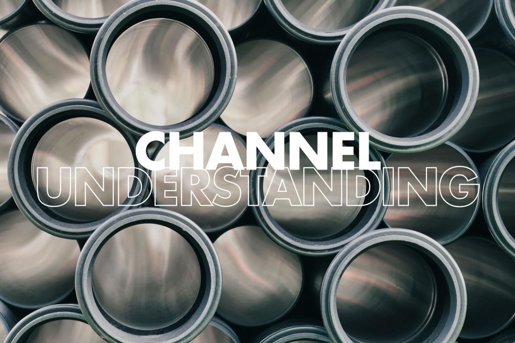 Close-up of stacked gray metal pipes with bold white text overlay “CHANNEL UNDERSTANDING” centred across the middle.

