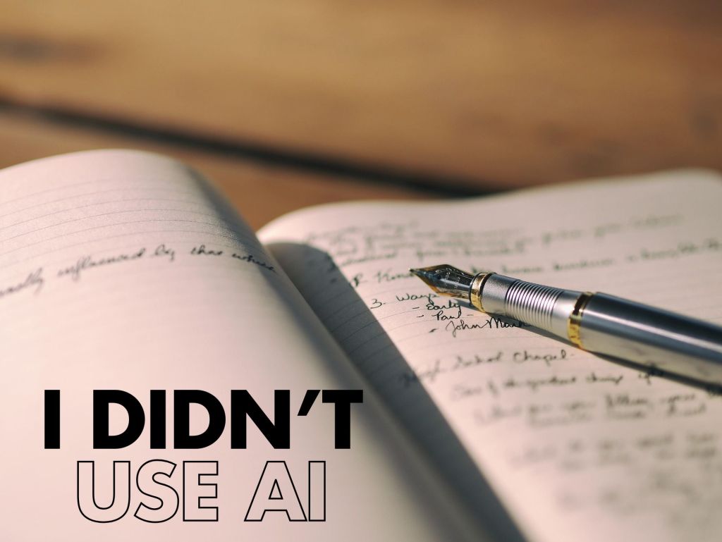 Close-up of an open notebook on a desk with a fountain pen resting on handwritten notes; large text at the bottom-left reads “I DIDN’T USE AI.”